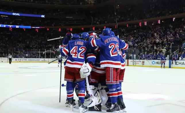 New York Rangers players react after goaltender Igor Shesterkin scored a goal during the third period of an NHL hockey game against the Tampa Bay Lightning Thursday, Oct. 1, 2026, in New York. (AP Photo/Pamela Smith)