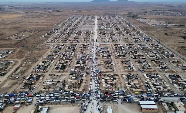 Trucks packed with belongings line the roads at al-Talayi camp as displaced families get ready to return to the Ras al-Ayn countryside, in Hassakeh, Syria, Tuesday, Oct. 13, 2026. Around 450 families are making the journey after seven years of displacement following a Turkish military offensive in 2019. (AP Photo/Baderkhan Ahmad)