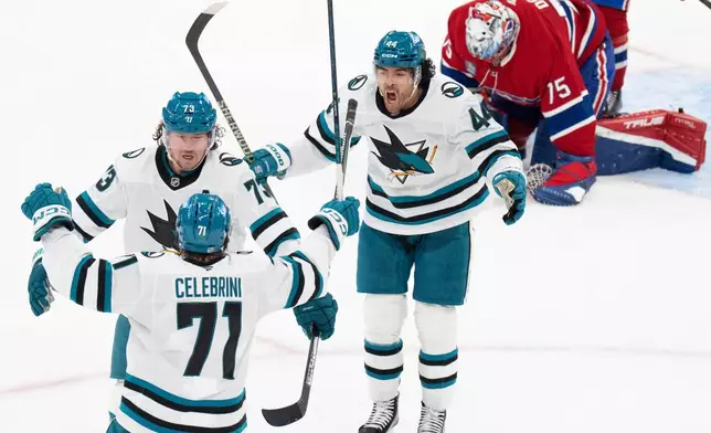 San Jose Sharks' Tyler Toffoli (73) celebrates his goal over Montreal Canadiens goaltender Jakub Dobes (75) with teammates Macklin Celebrini (71) and Kiefer Sherwood (44) during the third period of an NHL hockey game in Montreal, Tuesday, Oct. 20, 2026. (Christinne Muschi/The Canadian Press via AP)