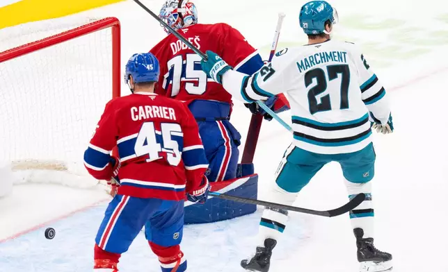 San Jose Sharks' Mason Marchment (27) celebrates as Montreal Canadiens goaltender Jakub Dobes (75) and Alexandre Carrier (45) look back at the puck following a goal by Sharks' Macklin Celebrini during overtime in an NHL hockey game in Montreal, Tuesday, Oct. 20, 2026. (Christinne Muschi/The Canadian Press via AP)