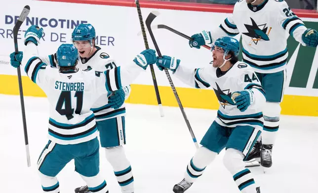 San Jose Sharks' Macklin Celebrini (71), second from left, celebrates his game-winning goal over the Montreal Canadiens with teammates Ivar Stenberg (41), Kiefer Sherwood (44) and Barclay Goodrow (23) during overtime in an NHL hockey game in Montreal, Tuesday, Oct. 20, 2026. (Christinne Muschi/The Canadian Press via AP)