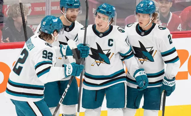 San Jose Sharks' Macklin Celebrini (71) celebrates his goal over the Montreal Canadiens with teammates from left, Igor Chernyshov (92), Nolan Allan (5) and Will Smith (2) during the first period of an NHL hockey game in Montreal on Tuesday, Oct. 20, 2026. (Christinne Muschi/The Canadian Press via AP)