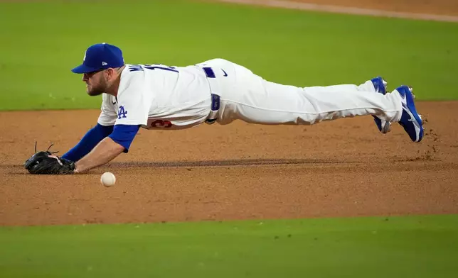 Los Angeles Dodgers third baseman Max Muncy can't stop an RBI base hit by Milwaukee Brewers shortstop Joey Ortiz during the eighth inning of Game 3 of baseball's National League Championship Series between the Milwaukee Brewers and the Los Angeles Dodgers, Wednesday, Oct. 14, 2026, in Los Angeles. (AP Photo/Mark J. Terrill)