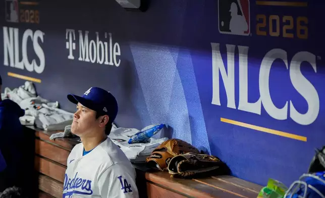 Los Angeles Dodgers designated hitter Shohei Ohtani sits in the dugout during the ninth inning of Game 3 of baseball's National League Championship Series between the Milwaukee Brewers and the Los Angeles Dodgers, Wednesday, Oct. 14, 2026, in Los Angeles. (AP Photo/Ashley Landis)