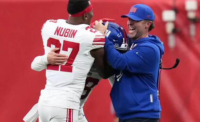 New York Giants head coach John Harbaugh, right, celebrates with safety Tyler Nubin (27), and quarterback J.J. McCarthy, center, following an overtime win over the Houston Texans in an NFL football game in Houston, Sunday, Oct. 25, 2026. (AP Photo/Eric Smith)