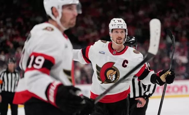 Ottawa Senators' Thomas Chabot, right, celebrates a goal by teammate Tim Stützle during the third period of an NHL hockey game against the New Jersey Devils in Newark, N.J., Monday, Oct. 12, 2026. (AP Photo/Seth Wenig)