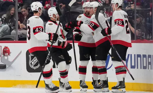 Ottawa Senators' Shane Pinto (12), second from right, celebrates his goal with teammates during the second period of an NHL hockey game against the New Jersey Devils in Newark, N.J., Monday, Oct. 12, 2026. (AP Photo/Seth Wenig)