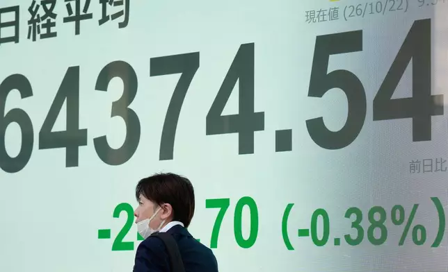 A person walks in front of an electronic stock board showing Japan's Nikkei index at a securities firm Thursday, Oct. 22, 2026, in Tokyo. (AP Photo/Eugene Hoshiko)