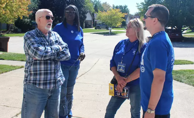Walter Usakowski, from left, a retired worker from the Ford Motor Co.'s Sterling Axe Plant who plans to vote for the union's slate of Democratic candidates in the midterms, talks with United Auto Workers union canvassers LaShawn Barnett, Kim Avouris and JJ Jewell in Shelby Township, Mich., Saturday, Sept. 26, 2026. (AP Photo/Jacqueline GaNun)