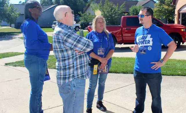 Walter Usakowski, second left, a retired worker from the Ford Motor Co.'s Sterling Axe Plant who plans to vote for the union's slate of Democratic candidates in the midterms, talks with United Auto Workers union canvassers LaShawn Barnett, from left, Kim Avouris and JJ Jewell in Shelby Township, Mich., Saturday, Sept. 26, 2026. (AP Photo/Jacqueline GaNun)