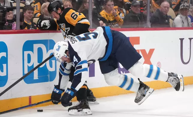 Pittsburgh Penguins' Rickard Rakell (67) collides with Winnipeg Jets' Dylan Samberg (54) during the second period of an NHL hockey game in Pittsburgh, Monday, Oct. 5, 2026. (AP Photo/Gene J. Puskar)