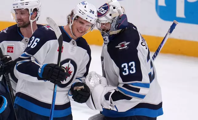 Winnipeg Jets goaltender Clay Stevenson (33) celebrates with Morgan Barron (36) at the end of an NHL hockey game against the Pittsburgh Penguins in Pittsburgh, Monday, Oct. 5, 2026. (AP Photo/Gene J. Puskar)