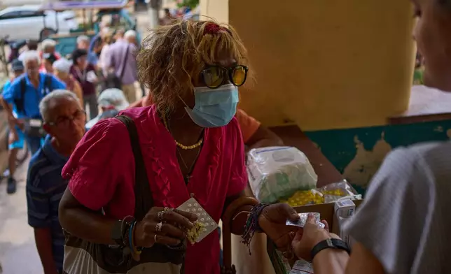 A woman receives medicine distributed through the “Medicine Is Not for Sale” community project in Havana, Cuba, Thursday, Oct. 8, 2026. (AP Photo/Ramon Espinosa)