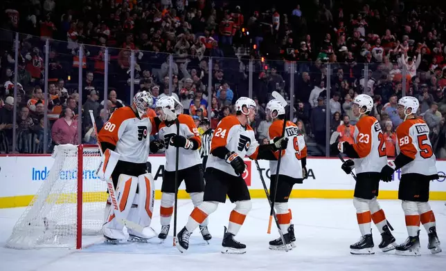 Philadelphia Flyers players celebrate after winning an NHL hockey game against the Ottawa Senators Saturday, Oct. 17, 2026, in Philadelphia. (AP Photo/Matt Slocum)