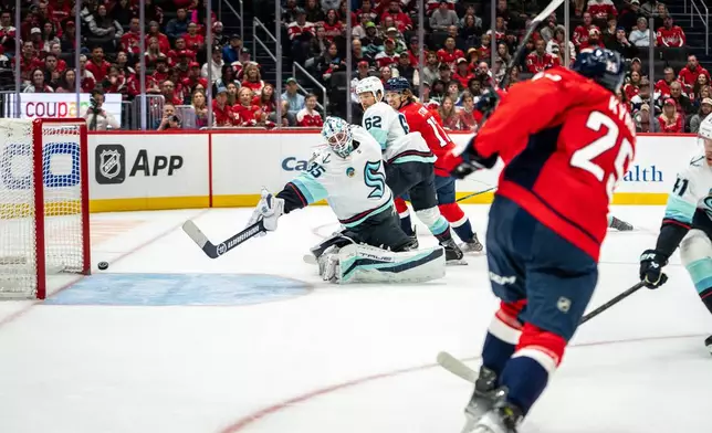 Washington Capitals right wing Jordan Kyrou (25) scores against Seattle Kraken goaltender Joey Daccord (35) during the first period of an NHL hockey game against the Seattle Kraken, Sunday, Oct. 11, 2026, in Washington. (AP Photo/Nathan Howard)