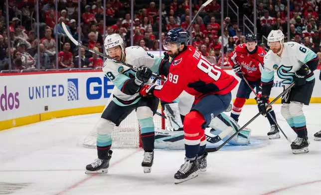 Seattle Kraken center Frederick Gaudreau (89) and Washington Capitals right wing Alex Tuch (89) in action during the first period of an NHL hockey game against the Seattle Kraken, Sunday, Oct. 11, 2026, in Washington. (AP Photo/Nathan Howard)