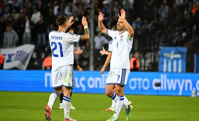Greece's Giorgos Masouras, right, and Konstantinos Tsimikas celebrate after the UEFA Nations League soccer match between Greece and Germany in Thessaloniki, northern Greece, Sunday, Oct. 4, 2026. (AP Photo/Giannis Papanikos)