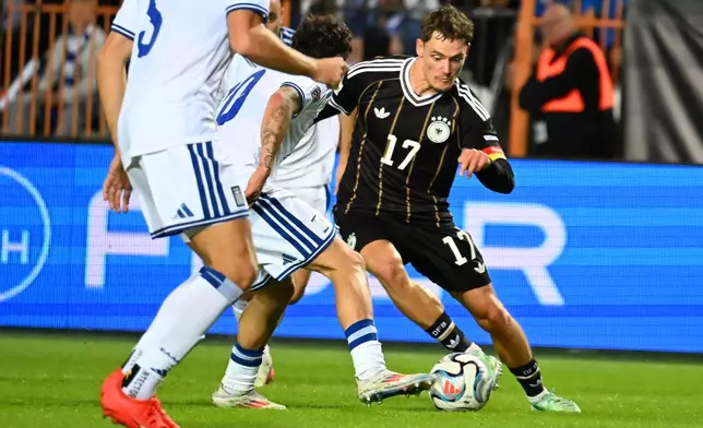 Germany's Florian Wirtz, right, challenges for the ball during the UEFA Nations League soccer match between Greece and Germany in Thessaloniki, northern Greece, Sunday, Oct. 4, 2026. (AP Photo/Giannis Papanikos)