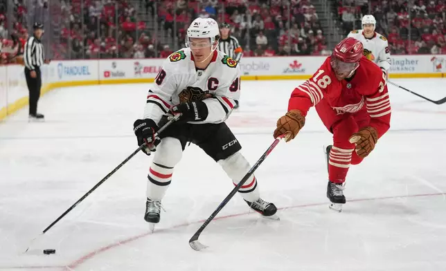 Chicago Blackhawks center Connor Bedard (98) protects the puck from Detroit Red Wings center Andrew Copp (18) in the second period of an NHL hockey game Thursday, Oct. 29, 2026, in Detroit. (AP Photo/Paul Sancya)
