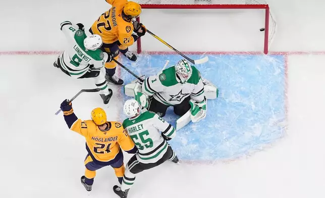 Nashville Predators left wing Nils Hoglander (21) celebrates his goal scored past Dallas Stars goaltender Casey DeSmith (1), defensemen Thomas Harley (55) and Nils Lundkvist (5)during the first period of an NHL hockey game Saturday, Oct. 3, 2026, in Nashville, Tenn. (AP Photo/George Walker IV)