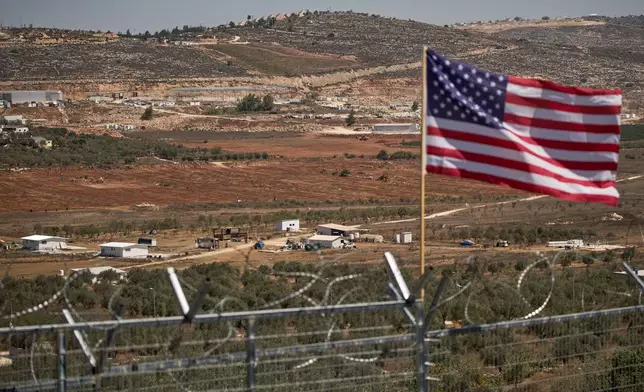 FILE - A U.S. flag waves at the entrance of a Palestinian house as an Israeli settler outpost stands in the middle of a valley next to olive trees in the West Bank town of Turmus Ayya, Sept. 9, 2026. (AP Photo/Leo Correa, File)