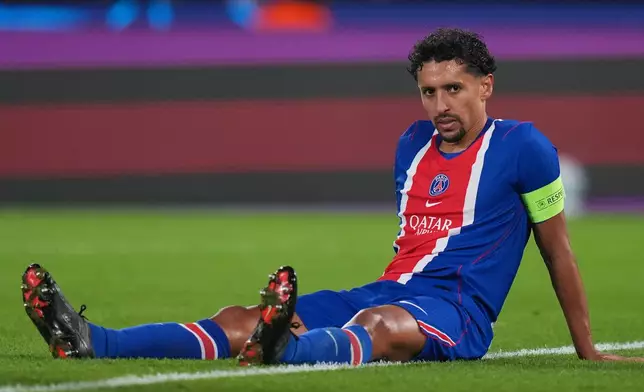 PSG's Marquinhos, right, sits on the field after appearing to suffer an injury during the Champions League opening phase soccer match between Paris Saint-Germain and FC Barcelona in Paris, Tuesday, Oct. 20, 2026. (AP Photo/Thibault Camus)