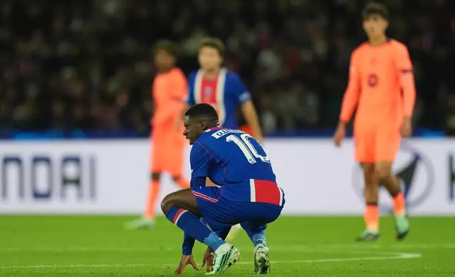 PSG's Ousmane Dembele reacts in pain after sustaining an injury during the Champions League opening phase soccer match between Paris Saint-Germain and FC Barcelona in Paris, Tuesday, Oct. 20, 2026. (AP Photo/Thibault Camus)