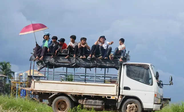 Boys watch performances of ethnic Intha troupe during the Phaung Daw Oo pagoda festival on Inle Lake, southern Shan State, Myanmar, Tuesday, Oct. 13, 2026. (AP Photo/Thein Zaw)