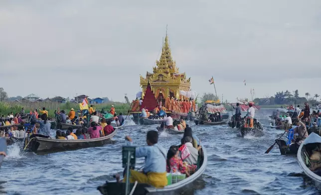 Barges carry Buddha statues float on Inle Lake during Phaung Daw Oo pagoda festival in southern Shan State, Myanmar, Thursday, Oct. 15, 2026. (AP Photo/Thein Zaw)