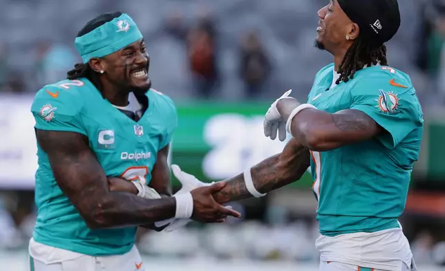 Miami Dolphins quarterback Malik Willis, left, and wide receiver Caleb Douglas (7) celebrate after the Dolphins defeated the New York Jets in an NFL football game in East Rutherford, N.J., Sunday, Oct. 25, 2026. (AP Photo/Adam Hunger)