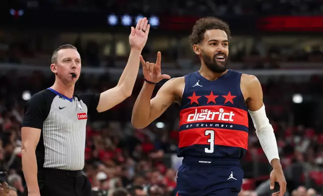 Washington Wizards guard Trae Young (3) gestures as the referee, left, gestures after making a three point basket during the first quarter of an NBA basketball game against the Chicago Bulls, Saturday, Oct. 24, 2026, in Chicago. (AP Photo/Jessie Alcheh)