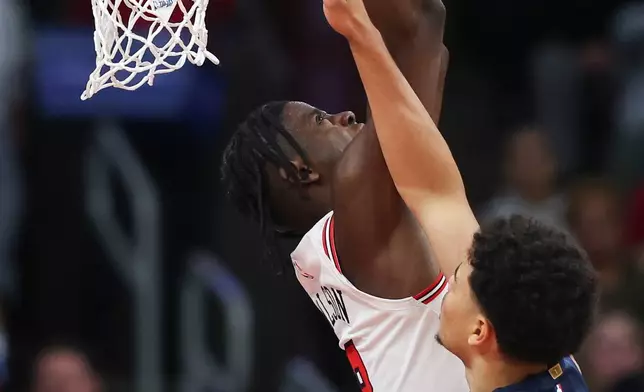 Chicago Bulls forward Caleb Wilson, back, dunks against Washington Wizards forward Kyshawn George, front, during the second quarter of an NBA basketball game, Saturday, Oct. 24, 2026, in Chicago. (AP Photo/Jessie Alcheh)