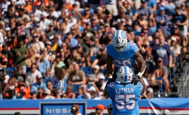 Tennessee Titans running back Tony Pollard (20) is lifted by offensive tackle JC Latham (55) after scoring a touchdown during the first half of an NFL football game against the Cleveland Browns in Nashville, Tenn., Sunday, Oct. 25, 2026. (AP Photo/George Walker IV)