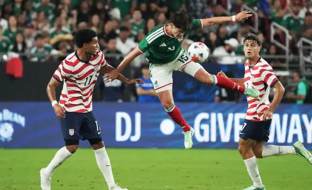 Mexico defenseman Israel Reyes kicks the ball in front of U.S. midfielder Malik Tillman (17) in the first half during an international friendly soccer match in Glendale, Ariz., Saturday, Oct. 3, 2026. (AP Photo/Rick Scuteri)