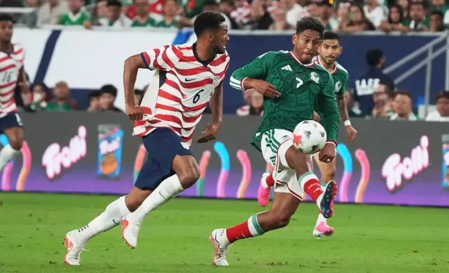 Mexico midfielder Luis Romo (7) dribbles the ball past U.S. defenseman Auston Trusty in the first half of an international friendly soccer match in Glendale, Ariz., Saturday, Oct. 3, 2026. (AP Photo/Rick Scuteri)