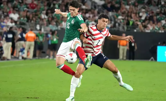 Mexico defensmane Israel Reyes (15) shields the ball from U.S. midfielder Gio Reyna in the first half during an international friendly soccer match in Glendale, Ariz., Saturday, Oct. 3, 2026. (AP Photo/Rick Scuteri)