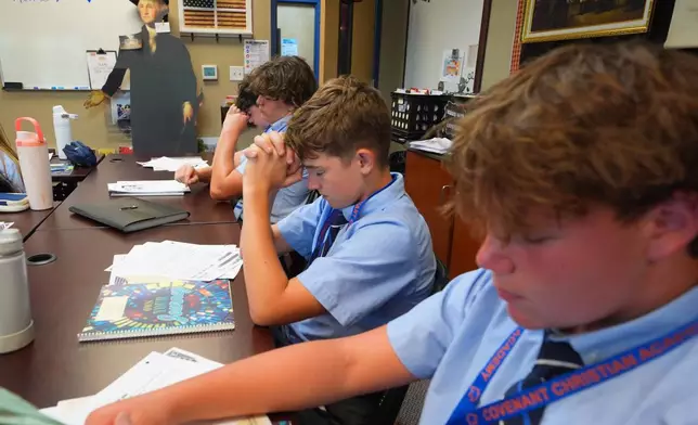 Students pray during a U.S. history class at Covenant Christian Academy in Colleyville, Texas, Wednesday, Aug. 12, 2026. (AP Photo/LM Otero)