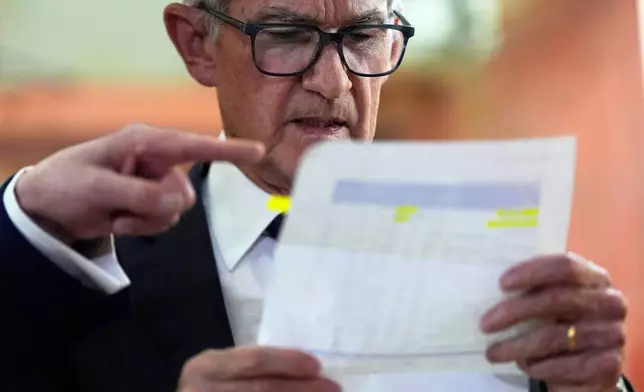 FILE- Federal Reserve Chairman Jerome Powell looks over a document of cost figures as President Donald Trump points during a visit to the Federal Reserve, Thursday, July 24, 2025, in Washington. (AP Photo/Julia Demaree Nikhinson, File)
