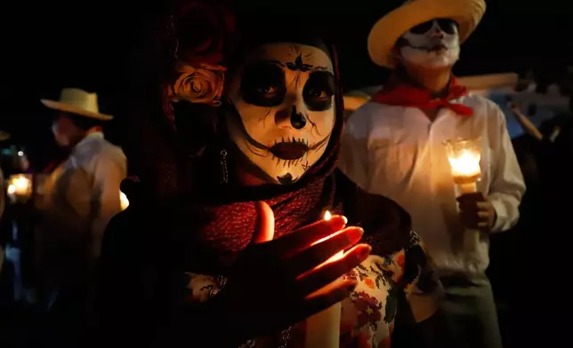 People with skull makeup march during the Paseo de las Animas parade as part of the Day of the Dead celebrations in Merida, Mexico, Friday, Oct. 30, 2026. (AP Photo/Martin Zetina)