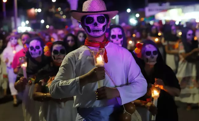 People with skull makeup march during the Paseo de las Animas parade as part of the Day of the Dead celebrations in Merida, Mexico, Friday, Oct. 30, 2026. (AP Photo/Martin Zetina)