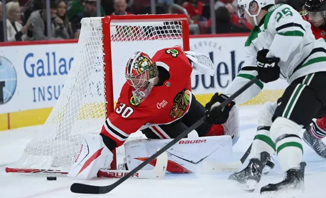 Chicago Blackhawks goalie Spencer Knight (30) makes a save against Dallas Stars' Arttu Hyry (25) during the first period of an NHL hockey game Saturday, Oct. 17, 2026, in Chicago. (AP Photo/Paul Beaty)