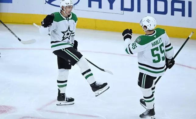 Dallas Stars' Jason Robertson (21) celebrates with teammate Thomas Harley (55) after scoring a goal during the second period of an NHL hockey game against the Chicago Blackhawks Saturday, Oct. 17, 2026, in Chicago. (AP Photo/Paul Beaty)