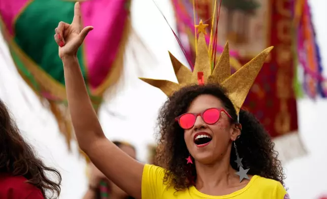 A supporter makes an "L" sign for Lula with her hand during a carnival party in support of Brazilian President Luiz Inacio Lula da Silva, who is running for reelection, on Copacabana beach in Rio de Janeiro, Brazil, Sunday, Sept. 27, 2026. (AP Photo/Silvia Izquierdo)