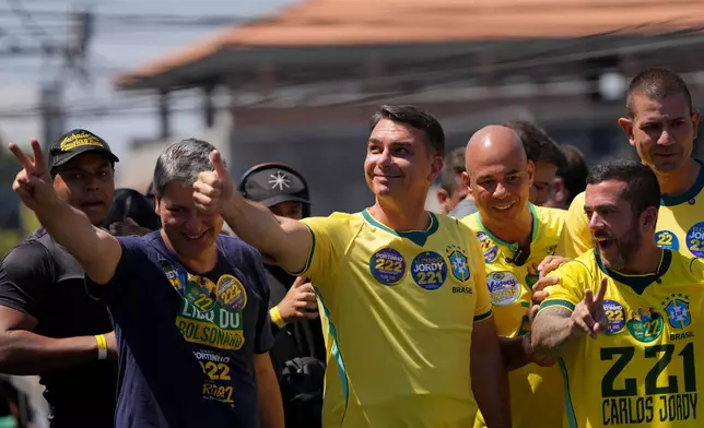 Opposition presidential candidate Sen. Flavio Bolsonaro, center, gives a thumbs-up to supporters during a campaign rally ahead of the October general election in Rio de Janeiro, Brazil, Saturday, Sept. 26, 2026. (AP Photo/Silvia Izquierdo)
