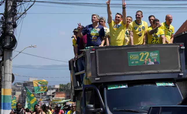 Opposition presidential candidate Sen. Flavio Bolsonaro, third left, waves to supporters during a campaign rally ahead of the October general election in Rio de Janeiro, Brazil, Saturday, Sept. 26, 2026. (AP Photo/Silvia Izquierdo)