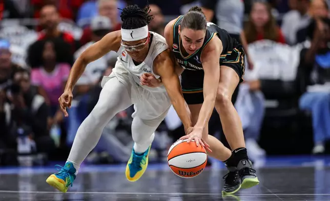 Atlanta Dream guard Allisha Gray, left, fights for possession with New York Liberty guard Pauline Astier, right, during the first half of Game 1 of the WNBA basketball semifinals Sunday, Oct, 4, 2026, in Atlanta. (AP Photo/Colin Hubbard)