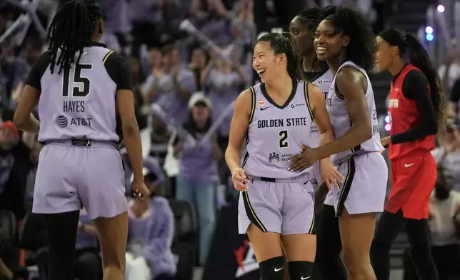 Golden State Valkyries guard Tiffany Hayes (15) celebrates with guard Kaitlyn Chen (2), forward Laeticia Amihere, rear, and guard-forward Kaila Charles during the second half of Game 1 of the WNBA basketball finals against the Atlanta Dream, Saturday, Oct. 17, 2026, in San Francisco. (AP Photo/Jeff Chiu)