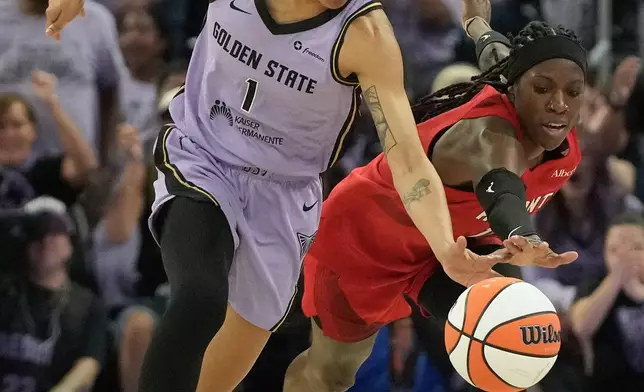 Golden State Valkyries forward Gabby Williams (1) reaches for the ball against Atlanta Dream guard Rhyne Howard during the first half of Game 1 of the WNBA basketball finals, Saturday, Oct. 17, 2026, in San Francisco. (AP Photo/Jeff Chiu)