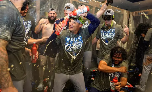 Los Angeles Dodgers players celebrate winning Game 4 of baseball's National League Division Series against the Atlanta Braves, Wednesday, Oct. 7, 2026, in Atlanta. (AP Photo/Mike Stewart)
