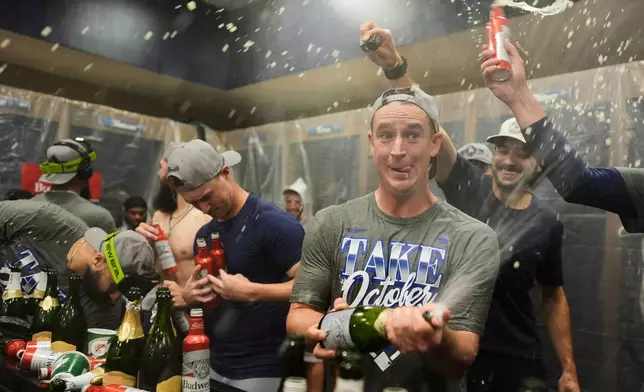 Los Angeles Dodgers players celebrate winning Game 4 of baseball's National League Division Series against the Atlanta Braves, Wednesday, Oct. 7, 2026, in Atlanta. (AP Photo/Mike Stewart)